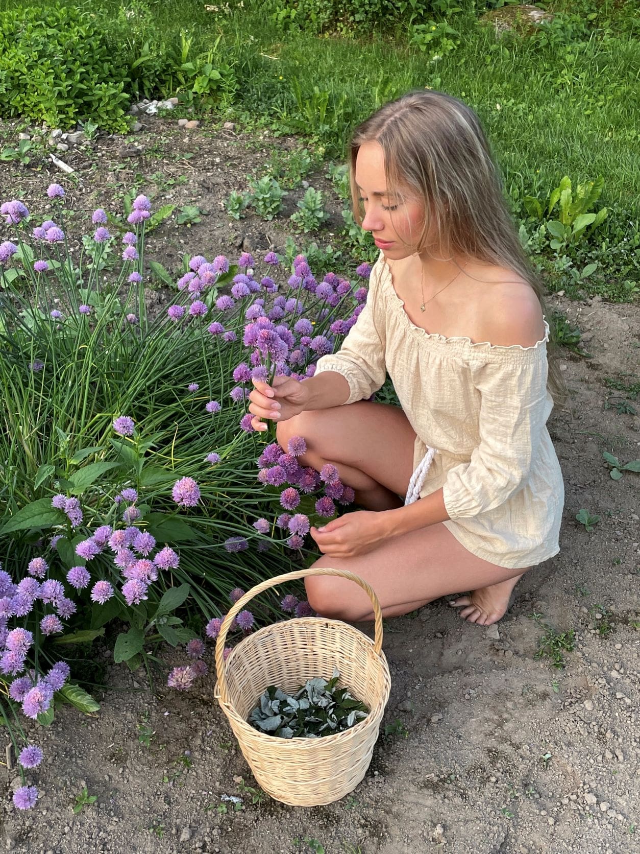 A picture of the creator of Earthy Vibes harvesting things in her garden.