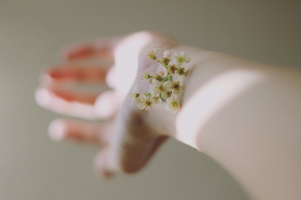A photo of a female hand with a flower on her wrist